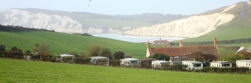 Caravans and farmhouse below the cliffs