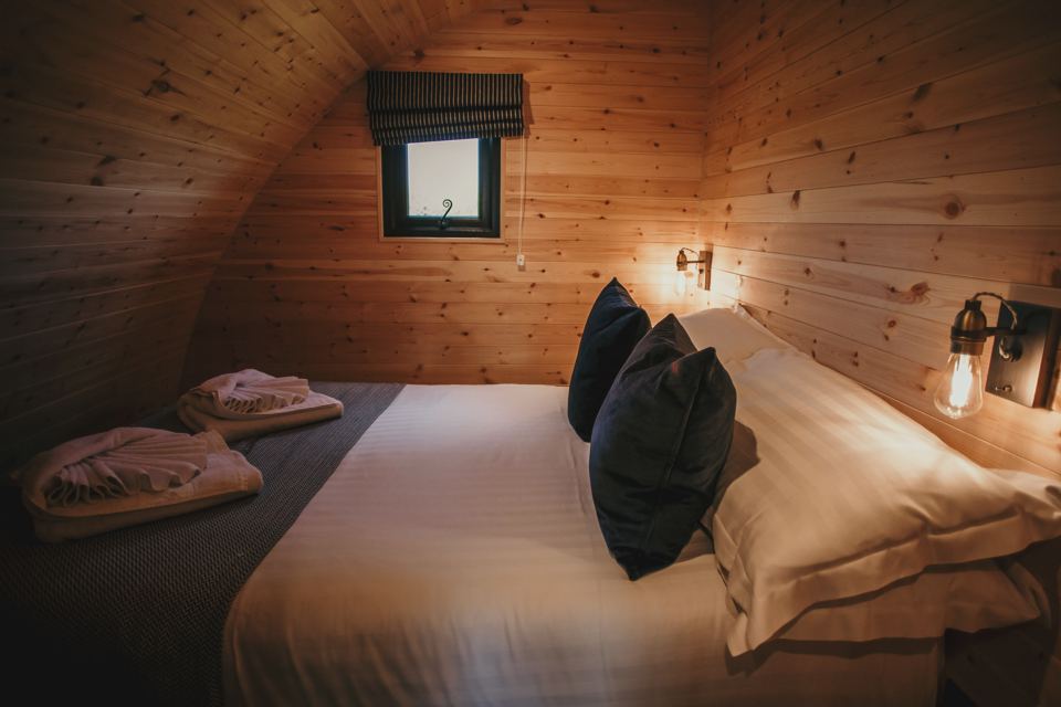 Bed inside a wooden pod